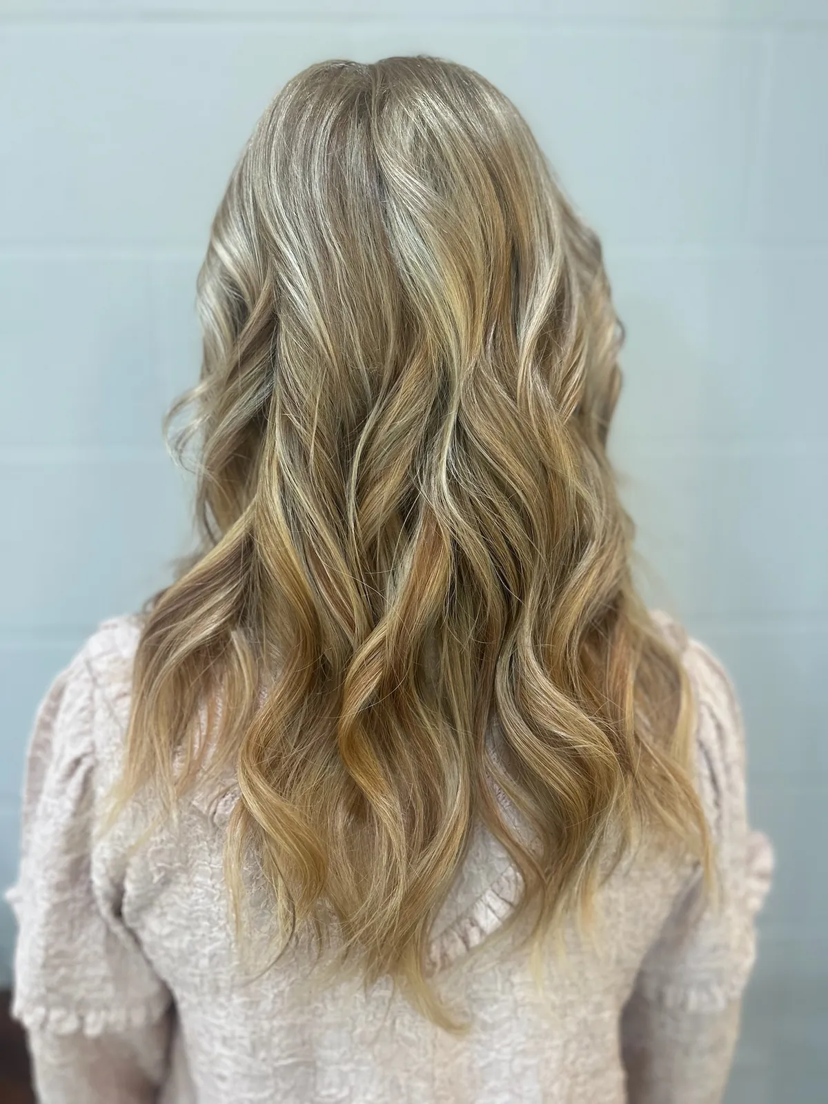 After: fuller dark blonde hair in soft waves.