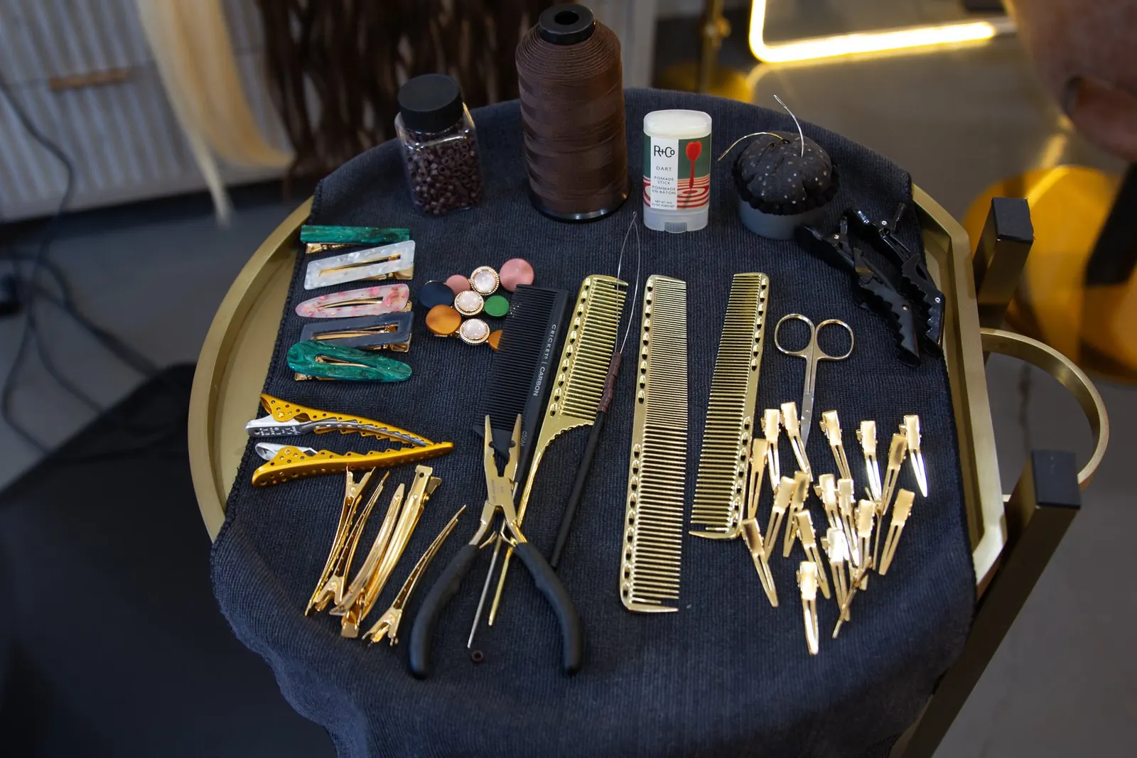 Gold shears, pliers and sectioning clips laid out on dark velvet.